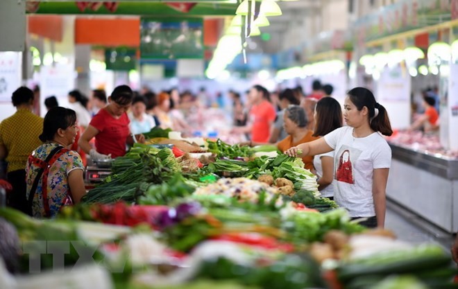 Người dân mua sắm tại một khu chợ ở Hải Nam, Trung Quốc. (Nguồn: AFP/TTXVN).