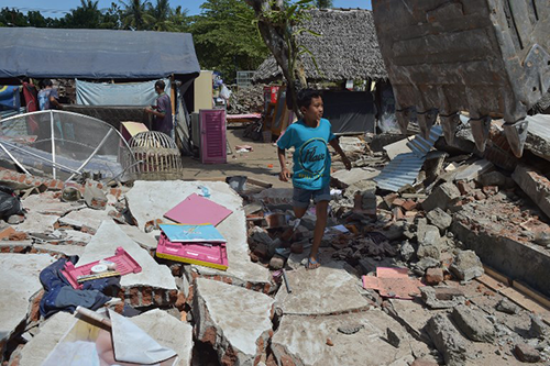 Người dân đảo Lombok, Indonesia, tìm kiếm của cải sót lại hôm 12/8 sau khi nhà cửa bị động đất phá hủy. Ảnh: AFP.