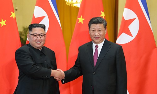 Lãnh đạo Triều Tiên Kim Jong-un bắt tay Chủ tịch Trung Quốc Tập Cận Bình trong lễ đón tiếp ở Đại lễ đường Nhân dân Bắc Kinh ngày 19/6. Ảnh: Xinhua.