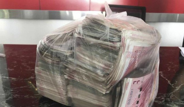 Túi tiền mặt đựng đầy những tờ 100 Nhân dân tệ mà cô Li nhặt được trong đống rác. (Nguồn: SCMP).