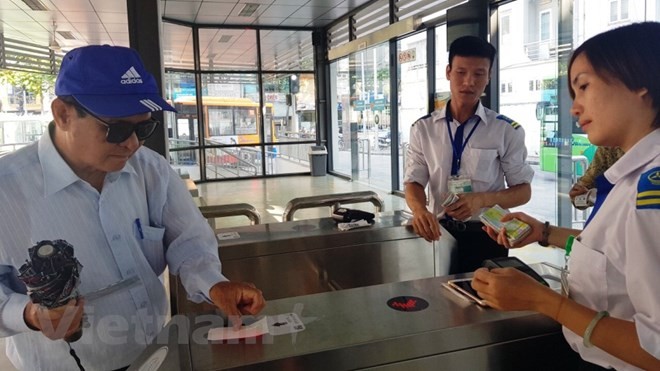 Khách sử dụng thẻ vé điện tử qua cổng kiểm soát để lên xe buýt nhanh BRT 01 Kim Mã-Yên Nghĩa. (Ảnh: Việt Hùng/Vietnam+).