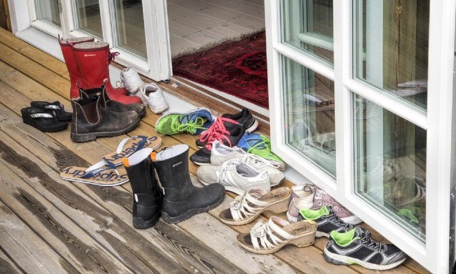 Tháo giày trước khi vào nhà để tránh mang những vi khuẩn gây bệnh vào trong nhà. Ảnh: KP.