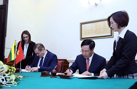 Phó Thủ tướng Phạm Bình Minh và Bộ trưởng Nội vụ Litva Eimutis Misiunas ký Hiệp định miễn thị thực cho người mang hộ chiếu ngoại giao và công vụ giữa hai nước. Ảnh: VGP/Hải Minh.