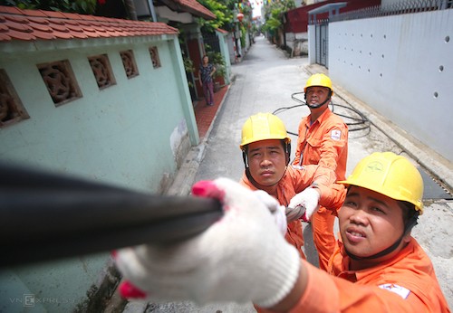 Công nhân điện lực Hà Nội sửa chữa đường dây điện sinh hoạt tại quận Long Biên. Ảnh: Ngọc Thành.
