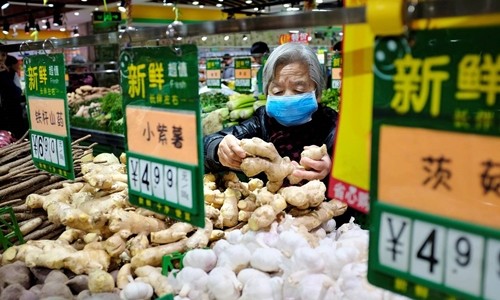 Một phụ nữ chọn gừng trong siêu thị ở Bắc Kinh hồi tháng 4. Ảnh: Reuters.