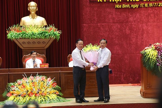 Ông Bùi Văn Tỉnh, Ủy viên BCH Trung ương Đảng, Bí thư Tỉnh ủy Hòa Bình tặng hoa chúc mừng ông Bùi Văn Khánh được bầu giữ chức Chủ tịch UBND tỉnh. 