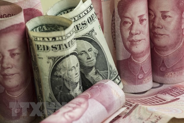 Đồng nhân dân tệ và đồng USD tại một ngân hàng ở Bắc Kinh, Trung Quốc. (Nguồn: AFP/TTXVN).