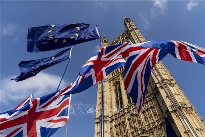 Cờ Anh (phía dưới) và cờ EU (phía trên) tại thủ đô London, Anh, ngày 28/3/2019. Ảnh: AFP/TTXVN.