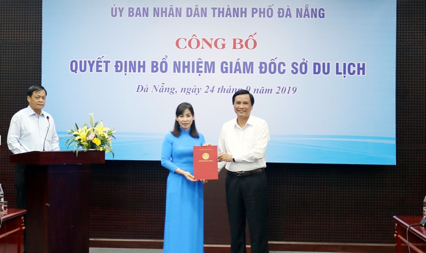 Ông Trần Văn Miên trao quyết định và tặng hoa cho bà Hạnh. 