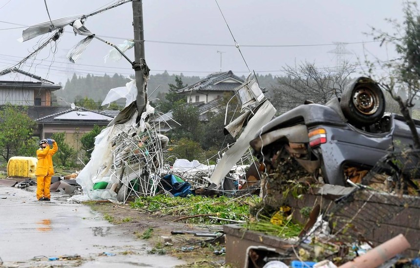 Một công nhân đứng giữa chụp ảnh những mảnh vỡ sau cơn bão Hagibis quét qua Ichihara, Chiba, gần Tokyo. (Nguồn: AP).