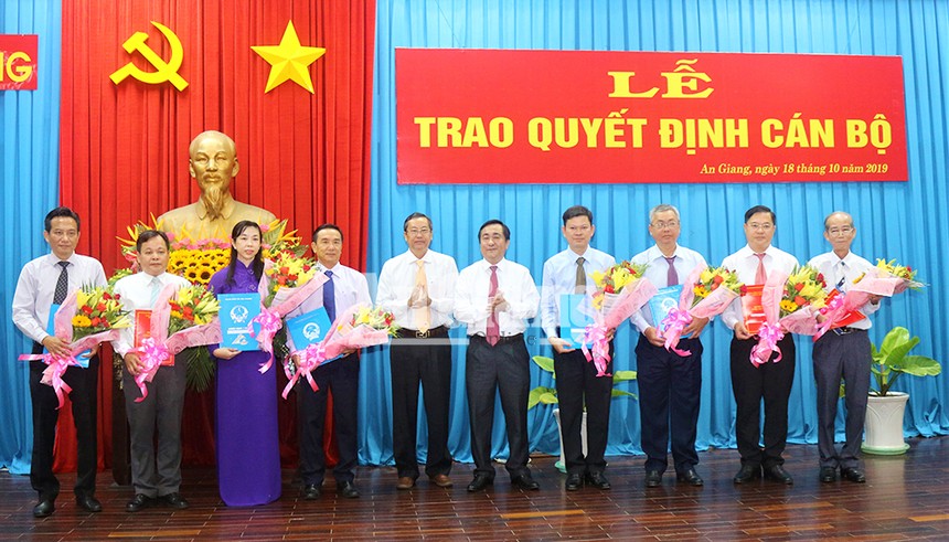 Phó Chủ tịch UBND tỉnh Anh Giang Lê Văn Nưng (thứ 5 bên trái) trao quyết định và tặng hoa cho các cán bộ được điều động, bổ nhiệm.