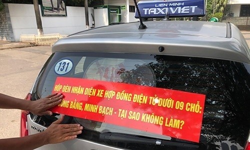 Nhiều hãng taxi truyền thống tại Hà Nội dán khẩu hiệu yêu cầu taxi công nghệ gắn mào. 