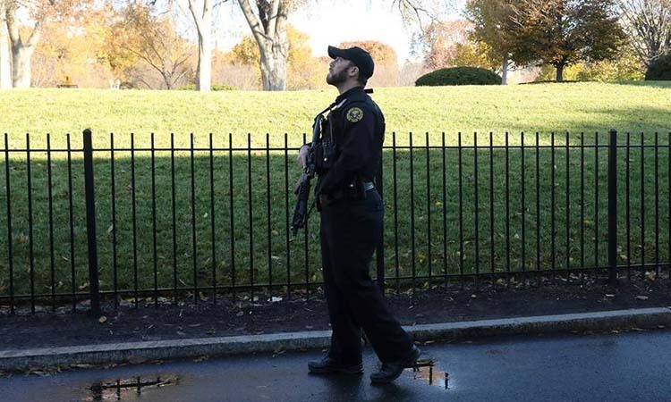 Một đặc vụ thuộc Cơ quan Mật vụ Mỹ quan sát bầu trời trong lúc Nhà Trắng bị phong tỏa hôm nay. Ảnh: Reuters.
