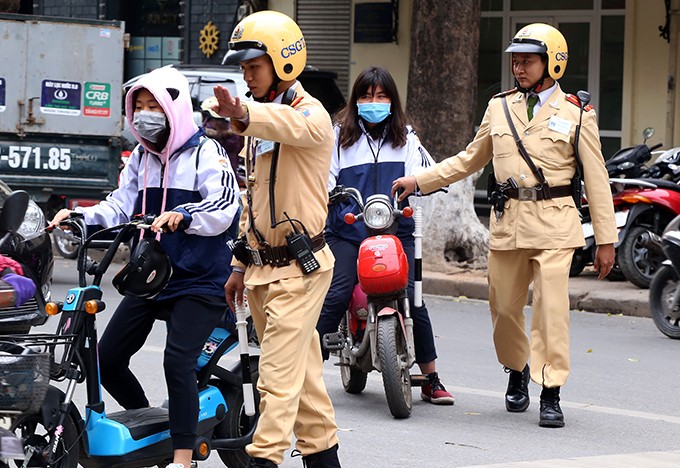 Cảnh sát giao thông Hà Nội trong một lần xử phạt người đi xe đạp điện vi phạm giao thông. Ảnh. Phương Sơn.