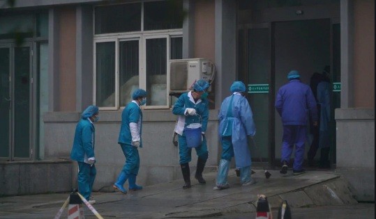 Các nhân viên y tế tẩy rửa lối vào một trung tâm y tế ở Vũ Hán ngày 22/1. (Ảnh: AP).