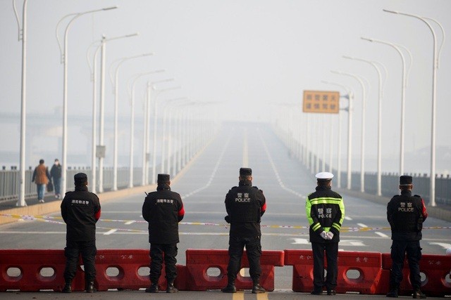Cảnh sát được triển khai canh gác tại trạm kiểm soát trước cây cầu bắc qua sông Trường Giang nối Hồ Bắc với Cửu Giang. (Ảnh: Reuters).