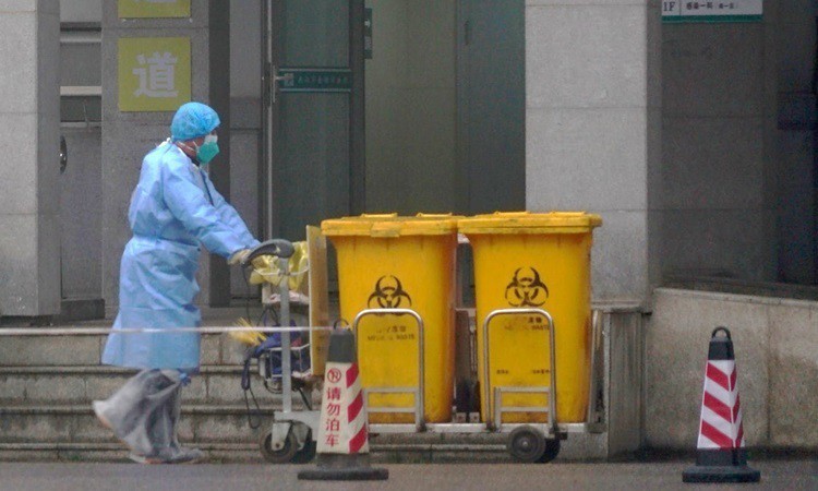 Công nhân thu gom rác thải y tế tại một trung tâm điều trị bệnh nhân nhiễm Covid-19 ở Vũ Hán hôm 22/1. Ảnh: 
AP.