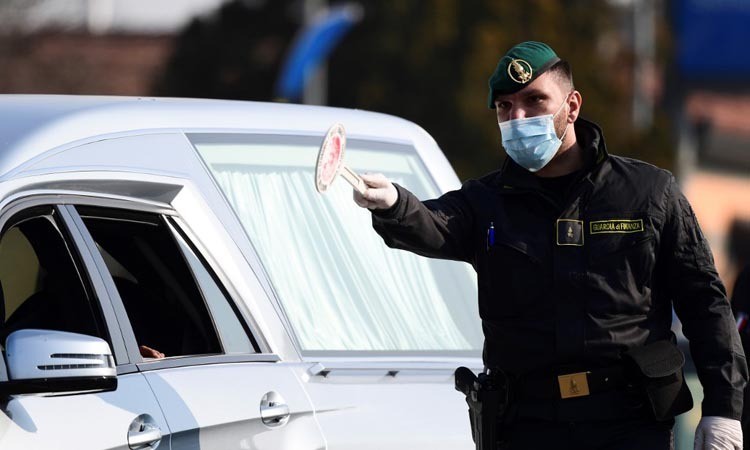 Nhân viên an ninh điều khiển giao thông tại một trạm kiểm soát ở thị trấn Zorlesco, vùng Lombardy, Italy hôm 24/2. Ảnh: AFP.