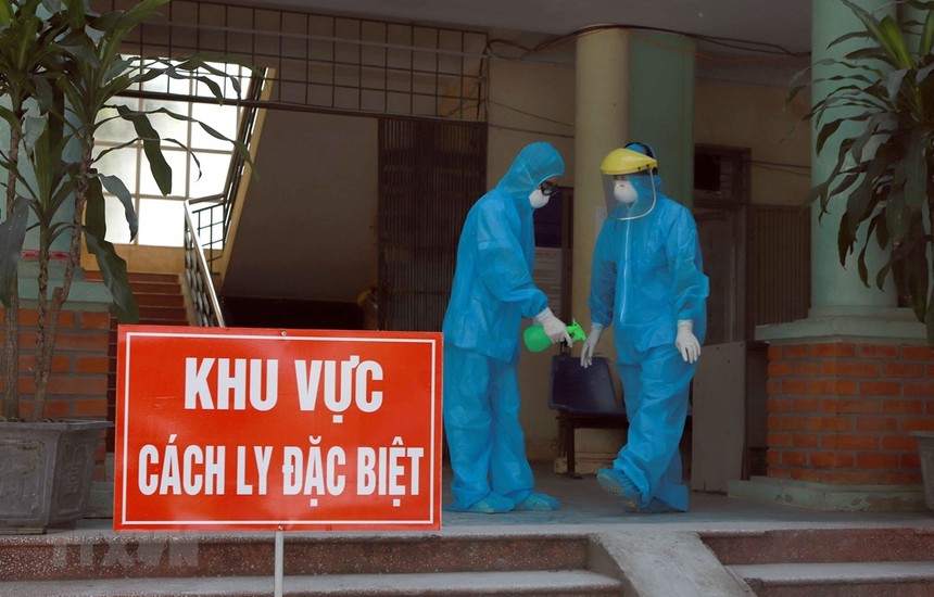 Các y bác sỹ Phòng khám Đa khoa khu vực Quang Hà mặc đồ bảo hộ và xịt nước xát khuẩn khi làm việc tại khu vực cách ly. (Ảnh: Hoàng Hùng/TTXVN).