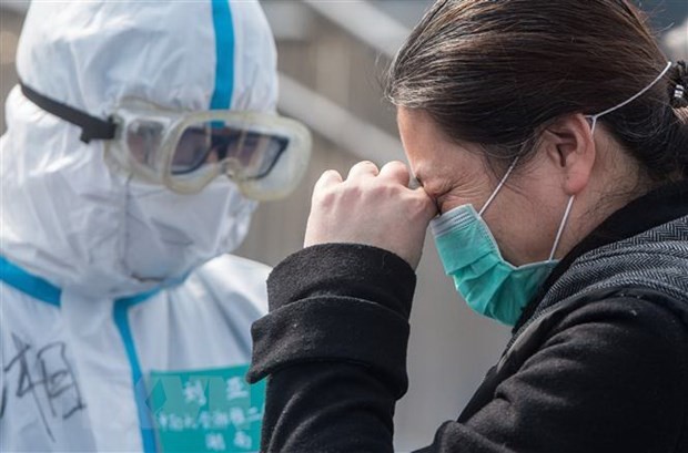 Bệnh nhân nhiễm COVID-19 tạm biệt bác sỹ sau khi được chữa khỏi tại bệnh viện ở Vũ Hán, tỉnh Hồ Bắc, Trung Quốc, ngày 10/3/2020. (Ảnh: THX/TTXVN).