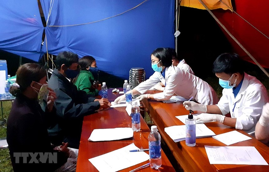 Sinh viên tình nguyện hướng dẫn người dân khai báo y tế tại chốt kiểm soát y tế thị xã Hương Trà. (Ảnh: Tường Vi/TTXVN).