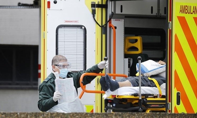 Nhân viên y tế chuyển một bệnh nhân nghi nhiễm nCoV xuống khỏi xe cứu thương tại St Thomas ở London ngày 31/3. Ảnh: AFP.