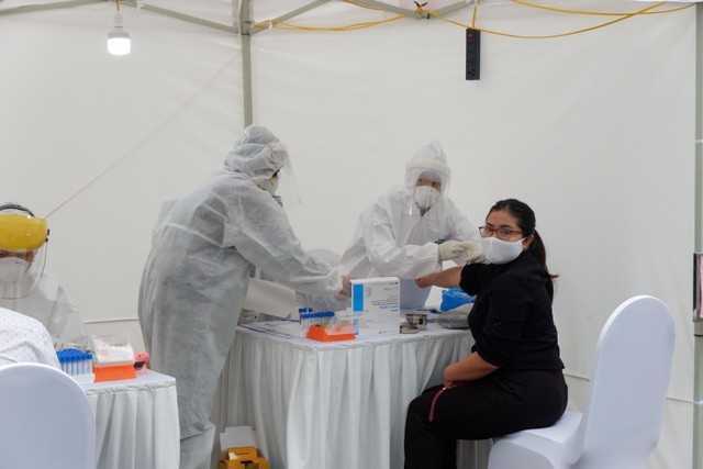 Y bác sỹ lấy mẫu test nhanh Covid-19 gần Bệnh viện Bạch Mai. (Ảnh: Nhật Minh).