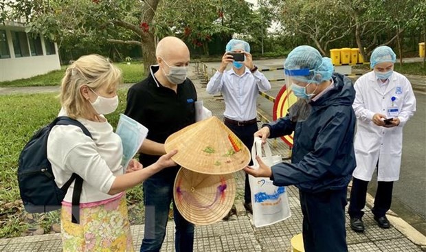 Lãnh đạo Sở Du lịch tỉnh Thừa Thiên-Huế tặng nón lá lưu niệm cho nữ bệnh nhân số 30. (Ảnh: Mai Trang/TTXVN).