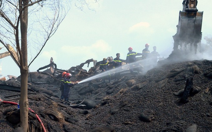 Cảnh sát liên tục đào bới, xịt nước ở kho hạt điều tránh bùng cháy trở lại.