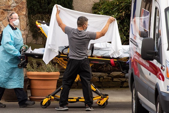 Nhân viên y tế đưa bệnh nhân COVID-19 lên xe cấp cứu tại bang Washington, Mỹ ngày 29/2. Ảnh: AFP.