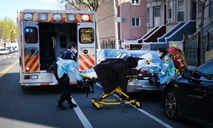 Nhân viên y tế di chuyển một bệnh nhân lên xe cứu thương ở New York ngày 11/4. Ảnh: AFP.