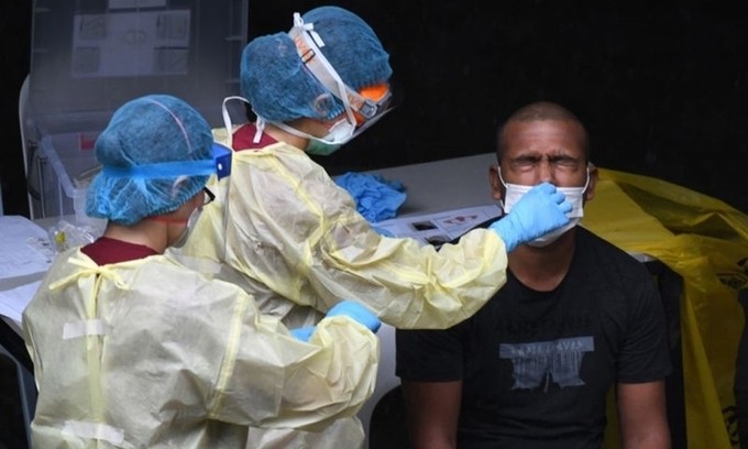 Nhân viên y tế xét nghiệm một lao động nhập cư tại Singapore ngày 27/4. Ảnh: AFP.