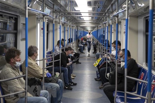 Hành khách đeo khẩu trang và găng tay phòng lây nhiễm COVID-19 trên tàu điện ngầm ở Moskva, Nga. (Ảnh: THX/TTXVN).