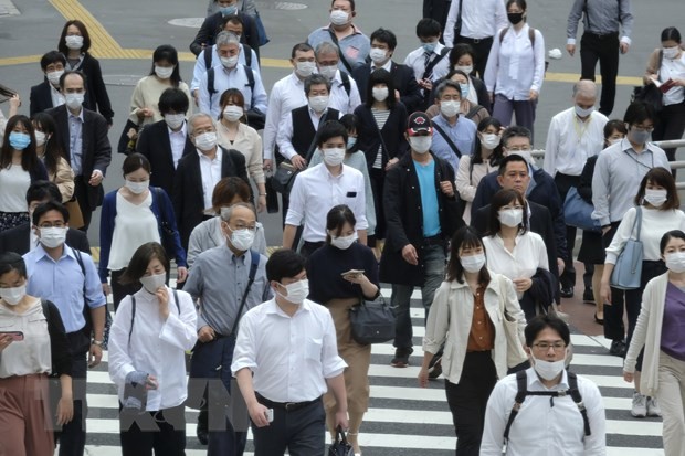 Người dân đeo khẩu trang phòng dịch COVID-19 khi di chuyển trên phố ở Tokyo, Nhật Bản ngày 26/5/2020. (Nguồn: AFP/TTXVN).