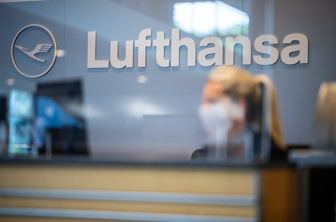 Nhân viên đeo khẩu trang làm việc trong một văn phòng của Lufthansa. Ảnh: DPA.