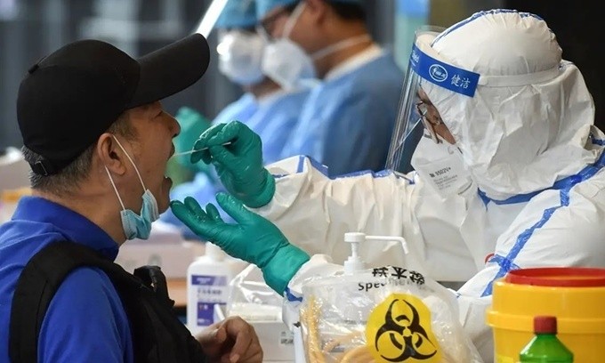 Nhân viên y tế lấy mẫu xét nghiệm nCoV cho một người dân ở thành phố Nam Kinh, tỉnh Giang Tô, Trung Quốc, ngày 15/6. Ảnh: AFP.