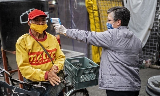 Một người đàn ông được đo thân nhiệt tại khu chợ ở thủ đô Mexico City của Mexico hôm 22/6. Ảnh: AFP.