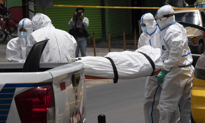 Nhân viên y tế xử lý xác một người chết trên đường tới bệnh viện ở El Salvador hôm 29/6. Ảnh: AFP.