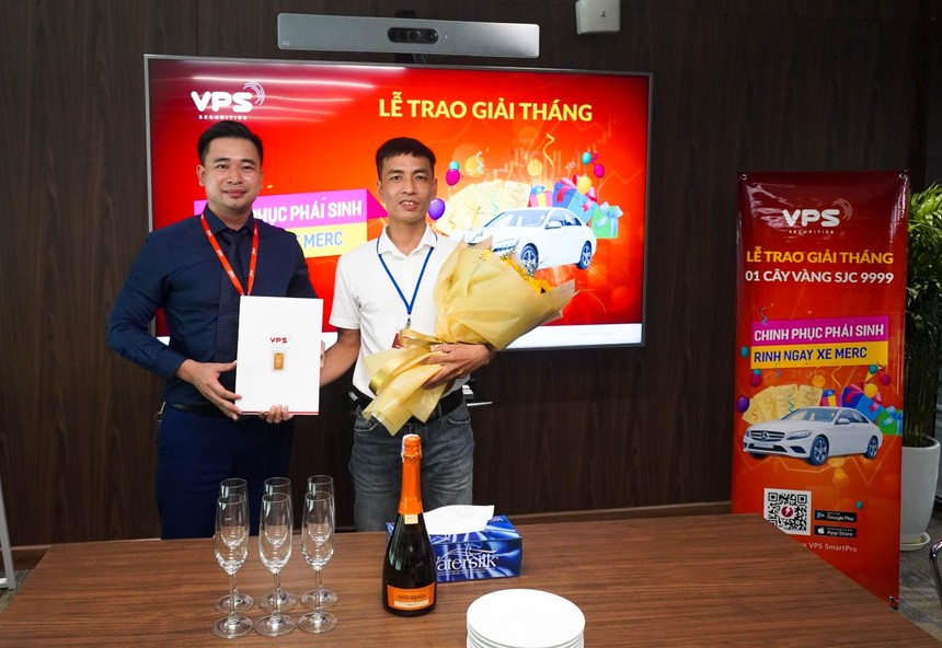Nhà đầu tư Hà Viết Trung (bên phải) nhận giải Nhất tháng 6 cuộc thi “Chinh phục phái sinh - Rinh ngay xe Merc” trị giá 1 cây vàng SJC 9999.