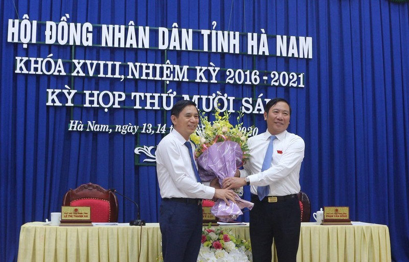 Ông Phạm Sỹ Lợi, Phó Bí thư thường trực Tỉnh ủy, Chủ tịch HĐND tỉnh Hà Nam tặng hoa chúc mừng ông Trần Xuân Dưỡng.