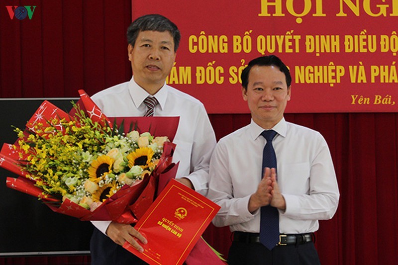 Chủ tịch UBND tỉnh Yên Bái ông Đỗ Đức Duy (bên phải) trao Quyết định và tặng hoa chúc mừng ông Đinh Đăng Luận.