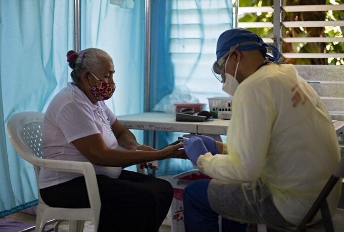 Y tá lấy mẫu máu của người phụ nữ tại El Salvador ngày 30/7. Ảnh: AFP.