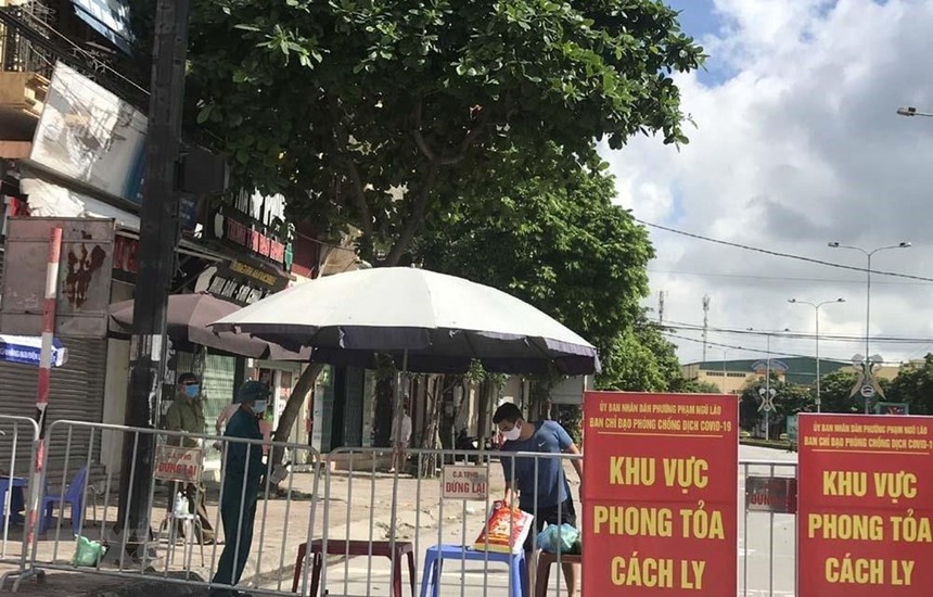 Người dân trong khu vực phong tỏa trên phố Ngô Quyền (Hải Dương) nhận thực phẩm tiếp tế tại hàng rào cách ly ngày 16/8. (Ảnh: Mạnh Minh/TTXVN)
.