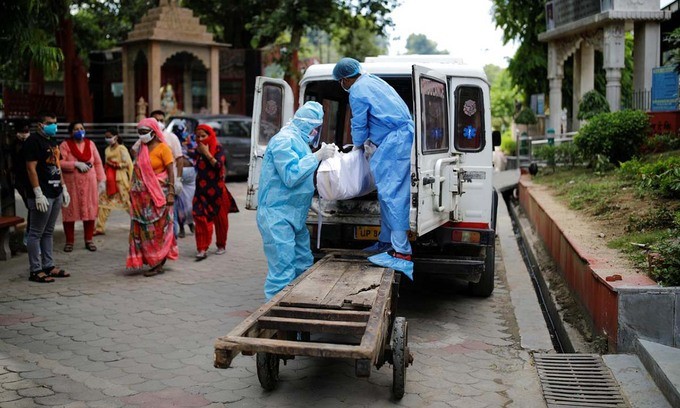 Các nhân viên y tế di chuyển thi thể một người chết vì nCoV tại New Delhi, Ấn Độ, hôm 22/8. Ảnh: Reuters.