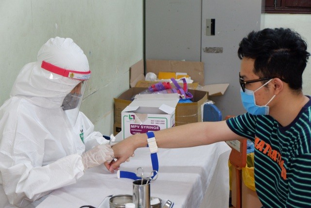 Y bác sĩ lấy mẫu xét nghiệm cho người dân từ vùng dịch trở về TP Hà Nội.