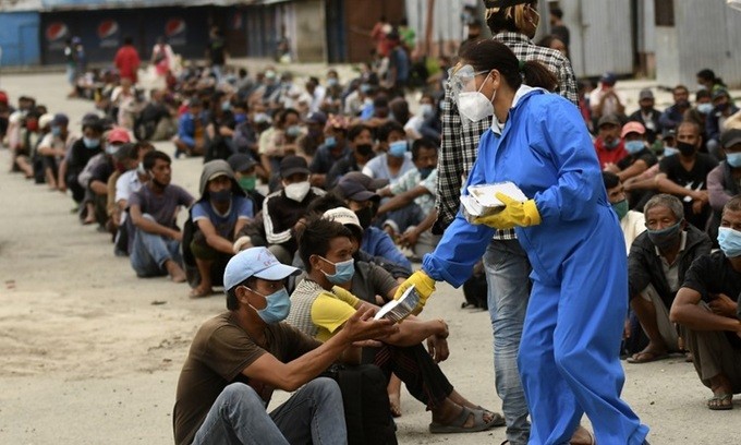 Tình nguyện viên phát thức ăn cho người dân tại khu vực bị áp hạn chế ngăn Covid-19 ở Kathmandu, Nepal hôm 31/8. Ảnh: AFP.