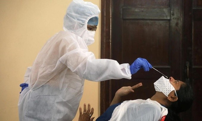 Nhân viên y tế lấy mẫu xét nghiệm nCoV cho một người dân ở Mumbai, Ấn Độ, ngày 12/9. Ảnh: Reuters.