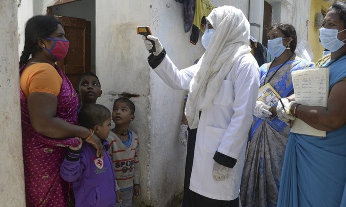 Nhân viên y tế kiểm tra thân nhiệt người dân ở thành phố Hyderabad, Ấn Độ, hôm 24/9. Ảnh: AFP.