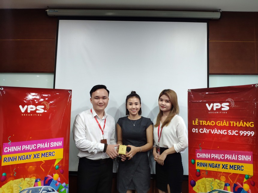 Nhà đầu tư Huỳnh Thị Ánh (váy đen, đứng giữa) nhận giải Nhất tháng 8 cuộc thi “Chinh phục phái sinh - Rinh ngay xe Merc” trị giá 1 cây vàng SJC 9999.