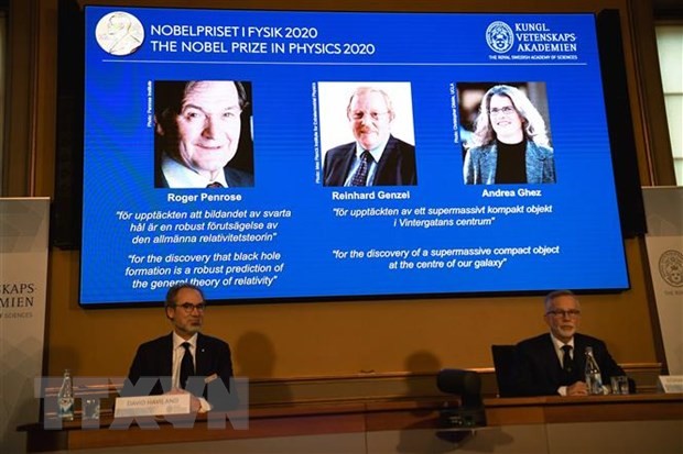 Chân dung ba nhà khoa học (trên màn hình, từ trái sang): Roger Penrose (người Anh), Reinhard Genzel (người Đức) và Andrea Ghez (người Mỹ) được xướng tên đoạt giải Nobel Vật lý 2020 tại buổi lễ ở Viện Hoàng gia Thụy Điển, thủ đô Stockholm ngày 6/10/2020. (Nguồn: AFP/TTXVN).
